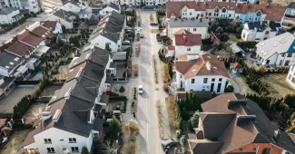 Acheteur regardant une maison en brique rénovée dans une commune résidentielle proche d'une ville