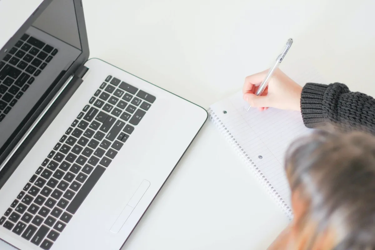 Espace de travail avec ordinateur portable, produits à tester et notes de rédaction pour un blog d'avis