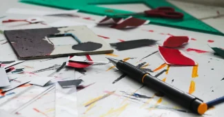 Espace de travail avec designs de produits dérivés, outils de mockup et ordinateur portable affichant une boutique en li