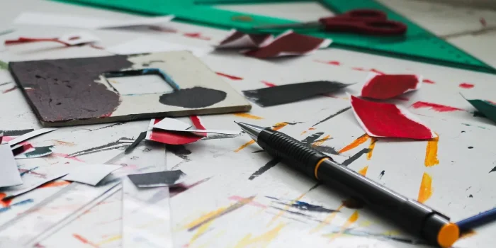 Espace de travail avec designs de produits dérivés, outils de mockup et ordinateur portable affichant une boutique en li