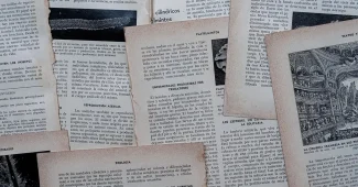 Mains tenant des documents hypothécaires et un plan d'étage sur un bureau avec ordinateur et calculatrice