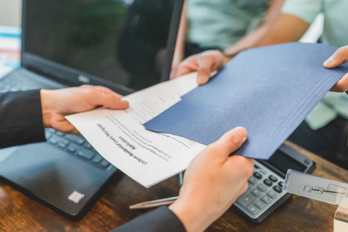 Dossier de documents immobiliers organisés sur un bureau professionnel