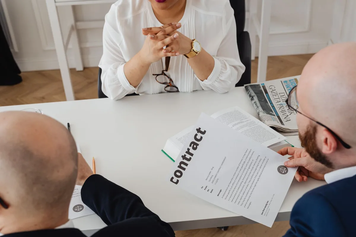 Deux personnes discutant d'un contrat à une table de réunion