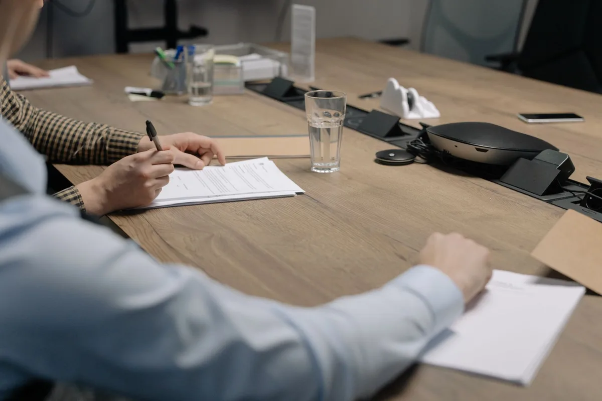 Co-propriétaires réunis autour d'une table avec documents et estimations immobilières