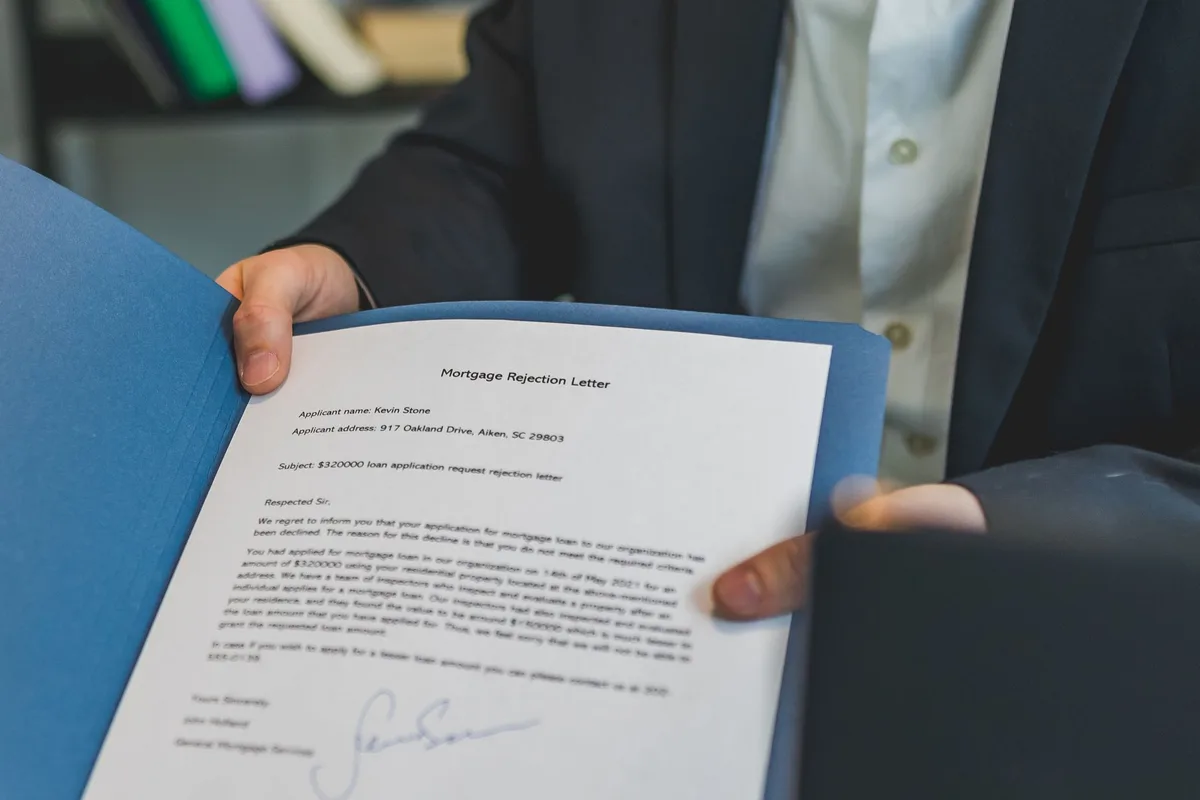 Personne examinant des documents bancaires avec une expression préoccupée