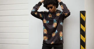 Personne portant un hoodie et un sweatshirt dans un cadre urbain lumineux