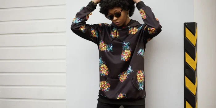 Personne portant un hoodie et un sweatshirt dans un cadre urbain lumineux
