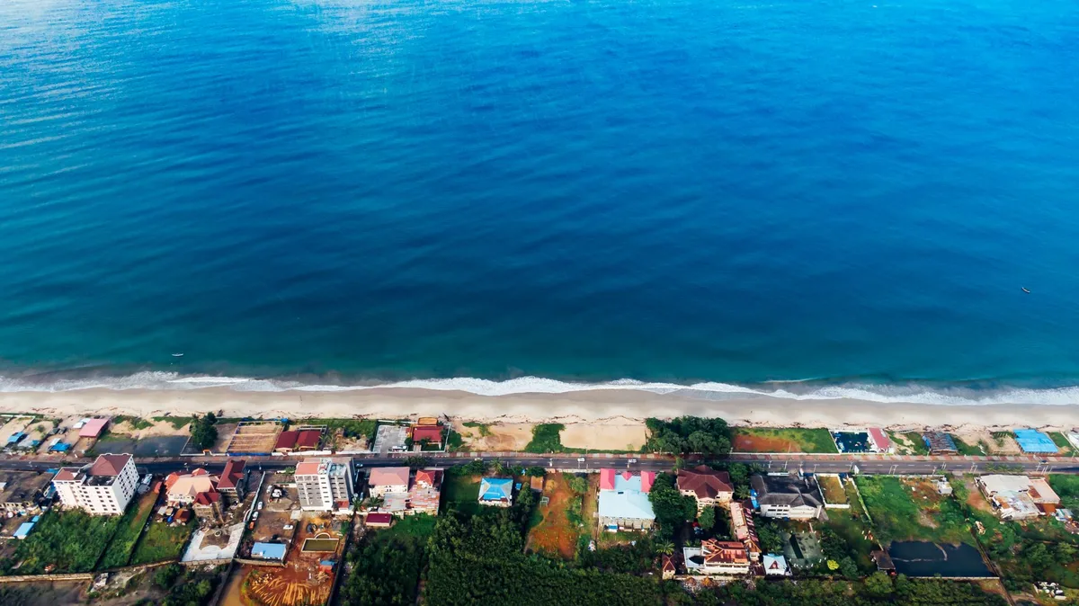 Vue côtière sur une plage avec maisons et horizon marin