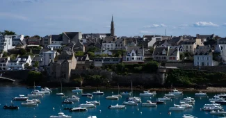 Promenade côtière avec port, bateaux et bâtiments, vue accessible et sereine