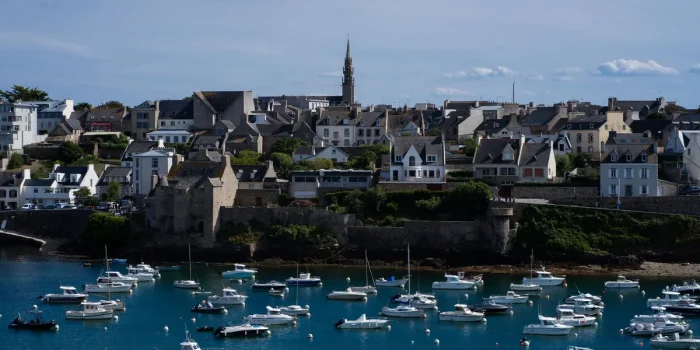 Promenade côtière avec port, bateaux et bâtiments, vue accessible et sereine