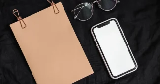 Espace de travail d'un designer avec maquettes de coques téléphone, nuanciers et logiciel de design