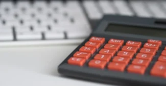 Table de cuisine en journée avec tableau d'amortissement, calculatrice et dossiers