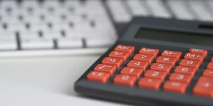 Table de cuisine en journée avec tableau d'amortissement, calculatrice et dossiers