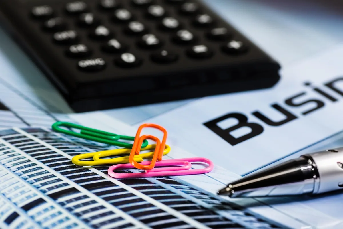 Dossier de prêt et calculatrice posés sur un bureau ensoleillé
