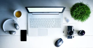 Bureau ensoleillé avec ordinateur portable, notes et tasse, symbolisant la formation SEO pratique