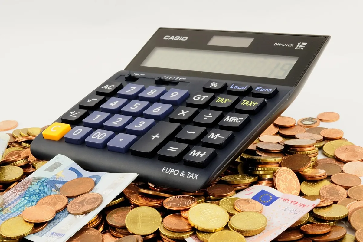 Feuilles chiffrées et calculatrice montrant économies de loyer