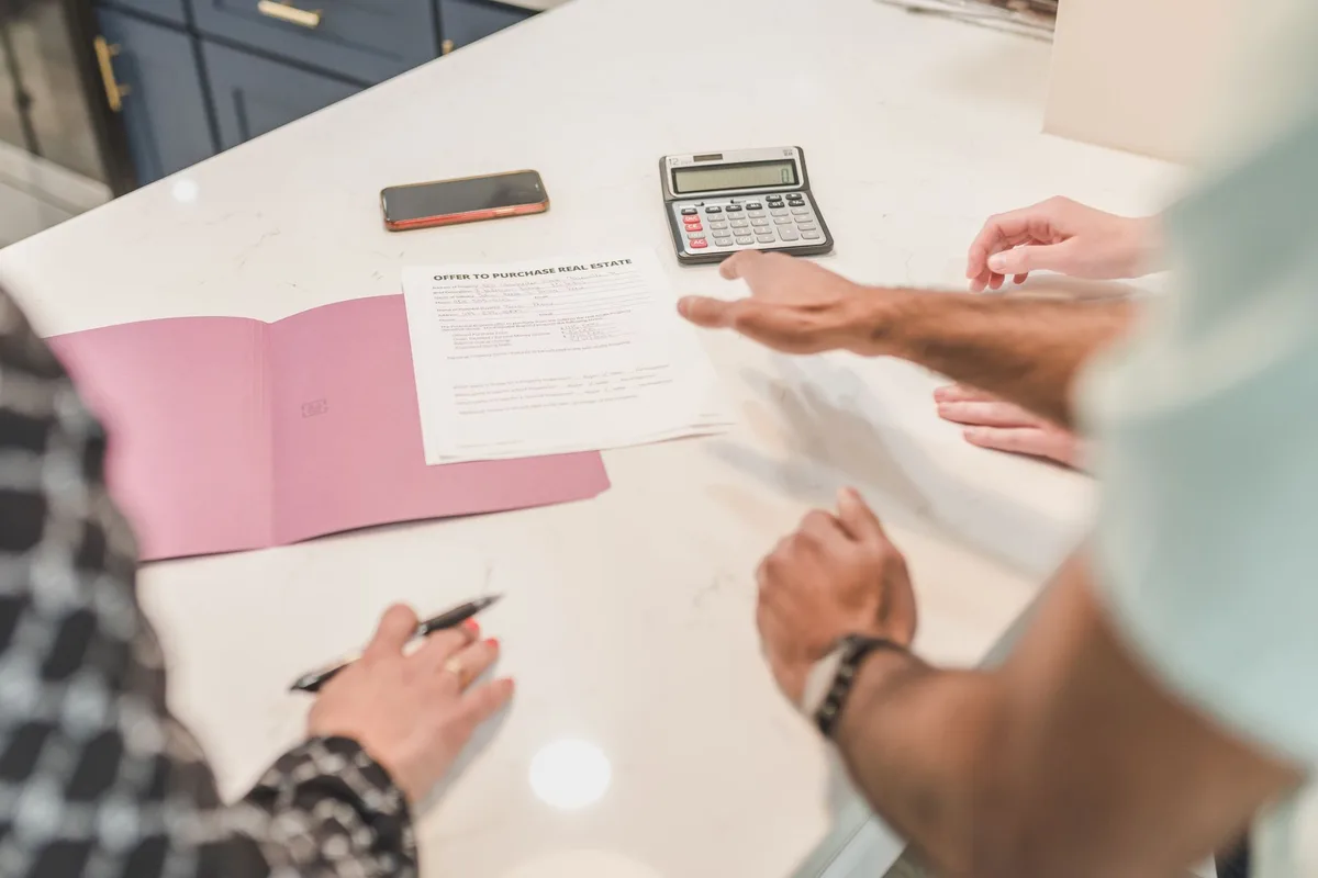 Documents de calcul de valeur nette d'une SCI posés sur une table avec une calculatrice
