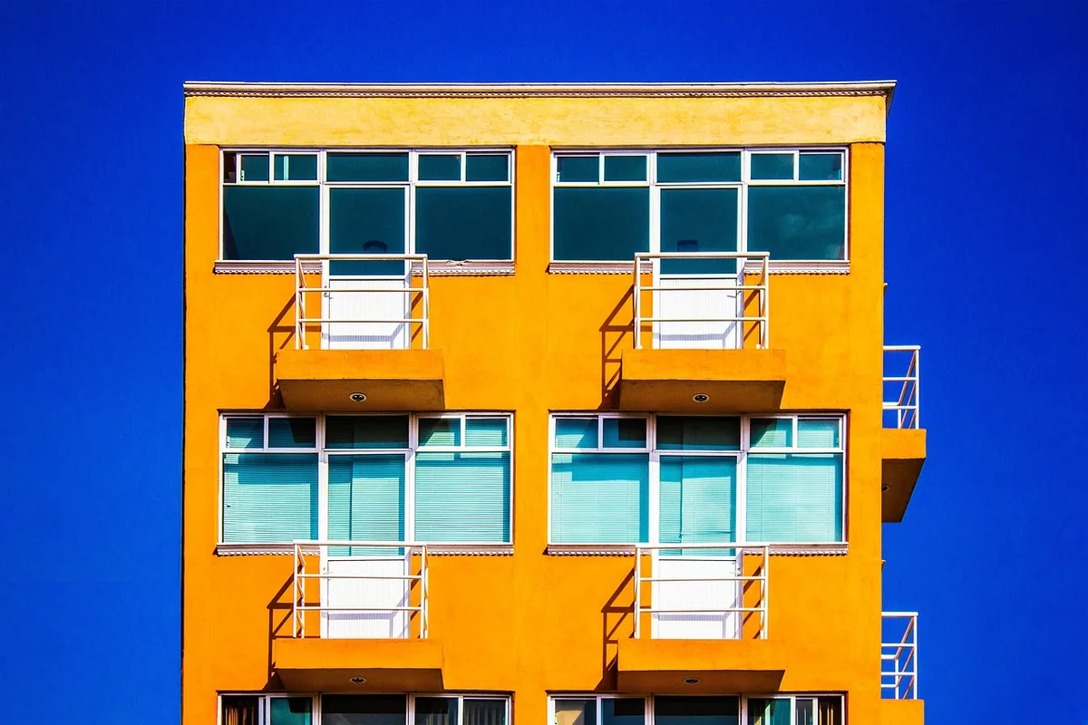 Factures et documents de copropriété posés sur une table près d'une fenêtre