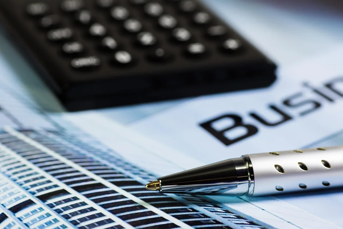 Table avec calculatrice, feuilles de budget et stylo pour établir un budget d'achat