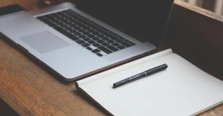 Bureau en journée avec ordinateur montrant une page de transfert de fichiers et smartphone