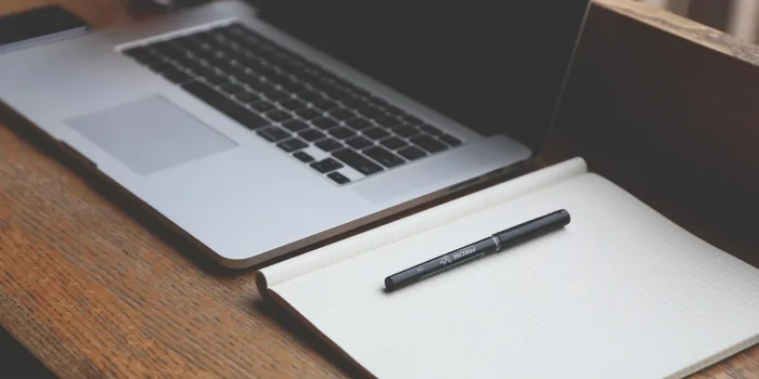 Bureau en journée avec ordinateur montrant une page de transfert de fichiers et smartphone