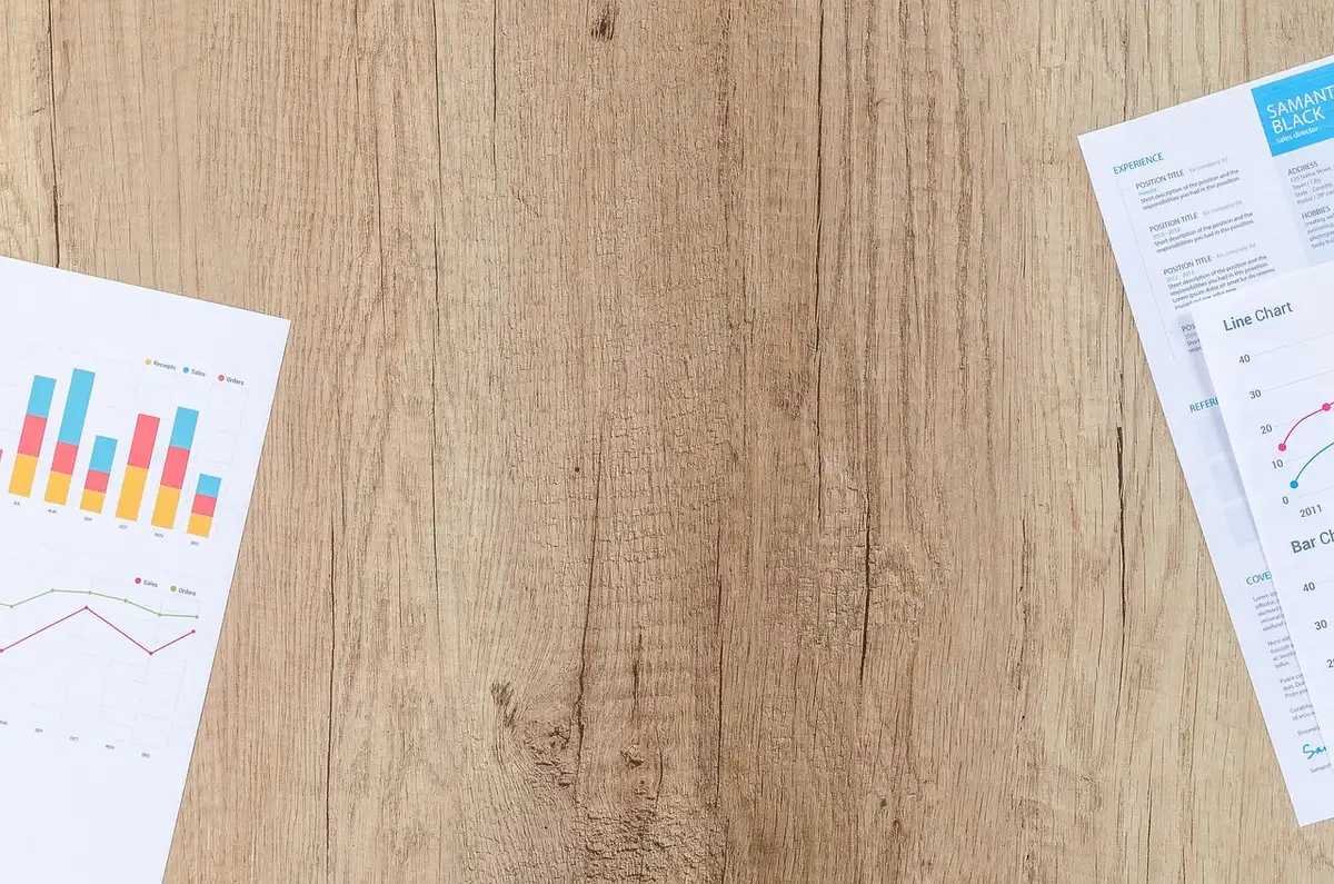 Feuilles de statuts et mains autour d'une table illustrant la constitution d'une SCI