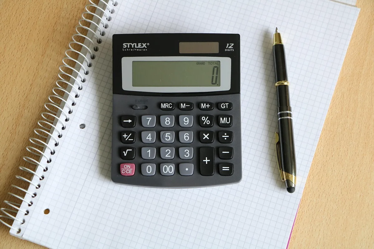 Propriétaire comparant des références locales avec calculatrice et documents