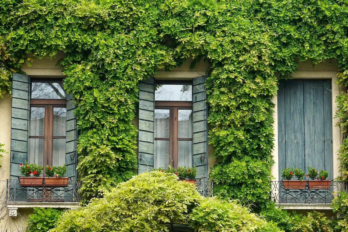 Main installant un verrou sur une porte-fenêtre au rez-de-chaussée