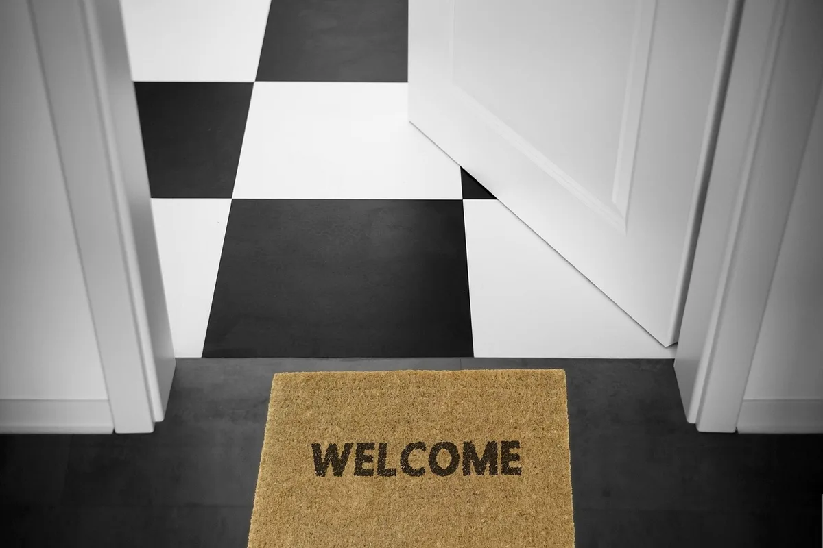 Entrée rangée avec paillasson propre et meuble bas